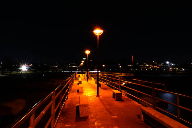 Pier at night with park in background.