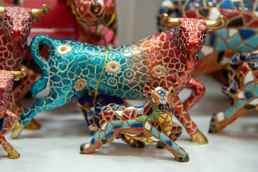 Valencia, Market, Spain ,2022, Multicolored mosaic figurine of bull in Gaudi style. Spanish traditional gifts in the souvenir shop. High quality photo