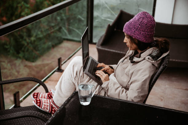 istock A young woman is working remotely from a mountain house with an incredible view, using her laptop - Stock Photo 1779101316