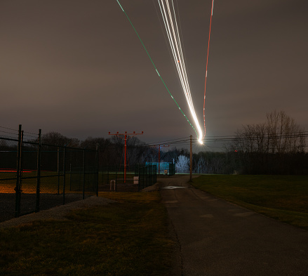 Long exposure of airplane light trails in sky over airport.