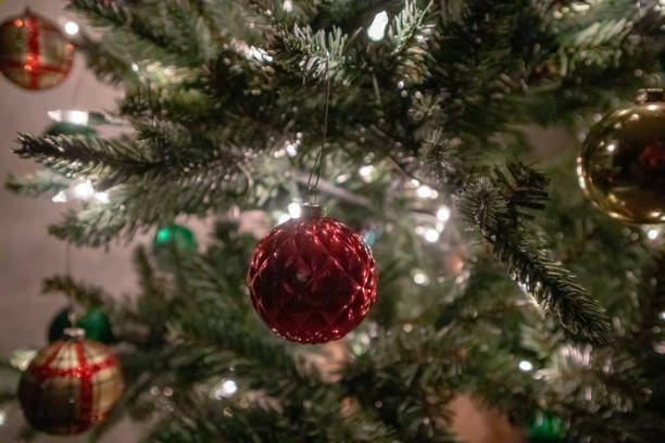 istock Sparkly red Christmas ball with lights on Christmas tree 1779111970