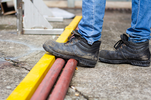 Wear safety shoes to ensure safety at work. construction workers wear safety shoes. concept.