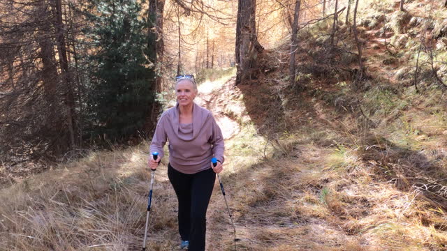 POV of mature woman hiking on path in the mountains