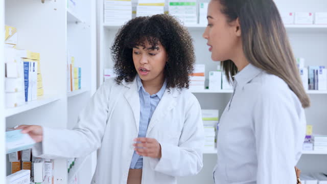 Friendly pharmacist explaining dosage instructions to woman in a drugstore. Healthcare worker offering good service and expert advice to customer by recommending and dispensing medicine from a shelf
