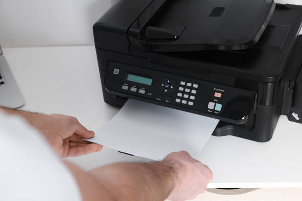 istock Man using modern printer at white desk in office, closeup 1779211124