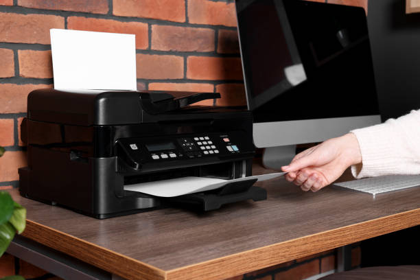 istock Woman using modern printer at wooden desk in home, closeup 1779211691
