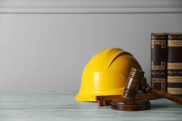 istock Construction and land law concepts. Judge gavel, construction helmet, ruler and books on light grey table, space for text 1779212853
