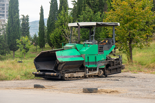 Asphalt paver machine. Asphalt finisher or paving machine placing a layer of asphalt. Repaving