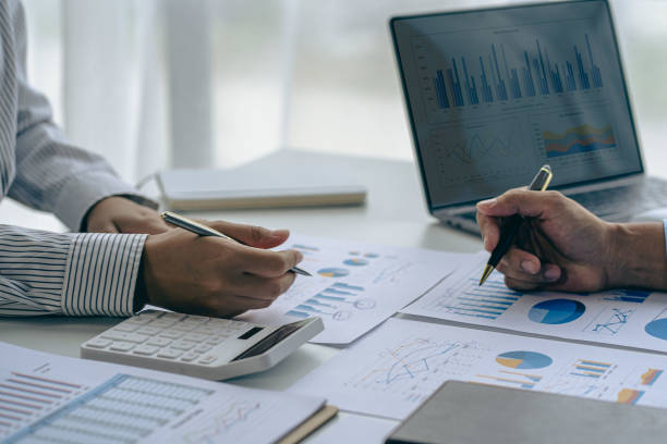 istock business team working They are analyzing financial reports and using calculators. accounting calculations And partners point to financial reports to analyze the company's sales plans. 1779225545