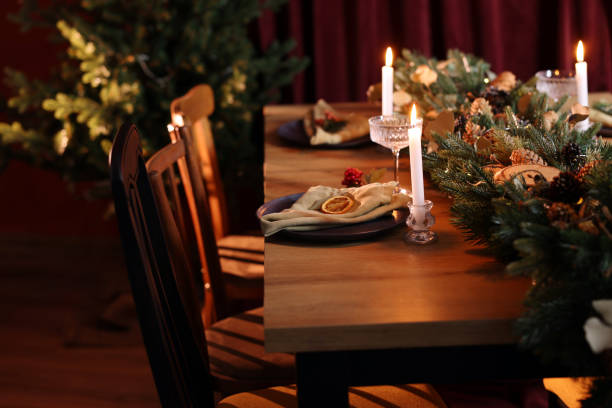 istock Dining table with burning candles and Christmas decor in stylish room. Interior design 1779226071