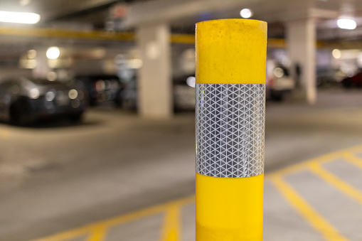 Yellow parking garage pole - close up - cars in background. Taken in Toronto, Canada.