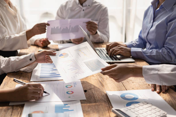 istock business team working They are analyzing financial reports and using calculators. accounting calculations And partners point to financial reports to analyze the company's sales plans. 1779227260