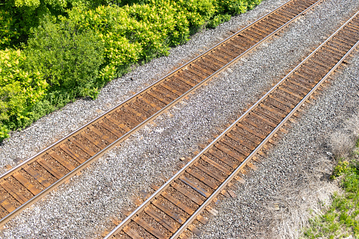 Aerial view of railroad tracks - green trees - gravel bed. Taken in Toronto, Canada.