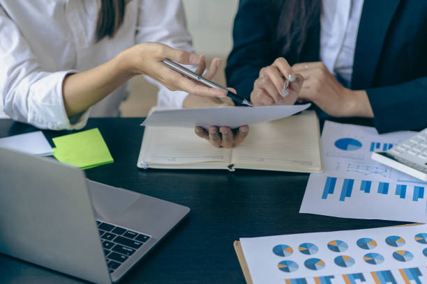 istock business team working They are analyzing financial reports and using calculators. accounting calculations And partners point to financial reports to analyze the company's sales plans. 1779227801