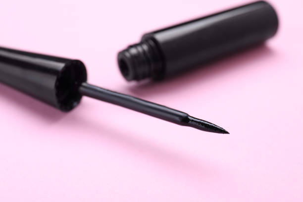 istock Black eyeliner on pink background, closeup. Makeup product 1779264375