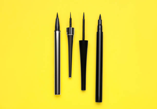 istock Black eyeliners on yellow background, flat lay. Makeup product 1779267271