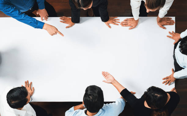 istock Businesspeople on meeting table pointing to empty space. Prudent 1779303826
