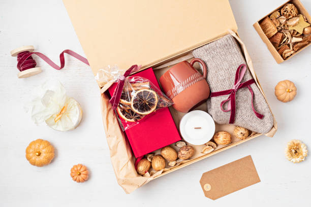 istock Preparing care package with warm socks, book, coffee cup, aroma spices. Personalized eco friendly basket for fall, winter holidays, christmas, wishig recovery to family, friend. Get well soon gift box 1779309594