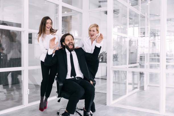 istock Happy colleagues are having fun together, rolling in an office c 1779312378