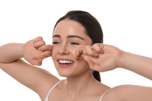istock Young woman massaging her face on white background 1779313537
