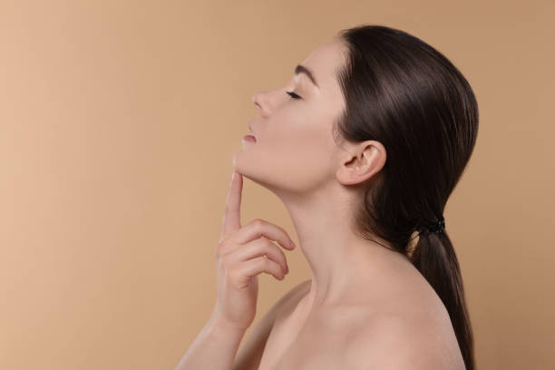 istock Young woman massaging her face on beige background. Space for text 1779314694