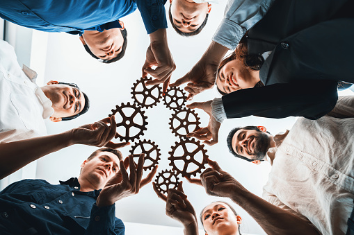 Business team joining cogwheel in circular together symbolize successful group of business partnership and strong collective unity teamwork in community workplace with productive efficiency. Prudent