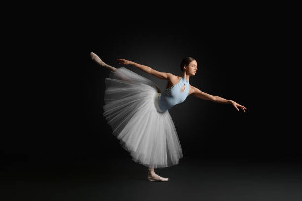 istock Young ballerina practicing dance moves on black background 1779328759