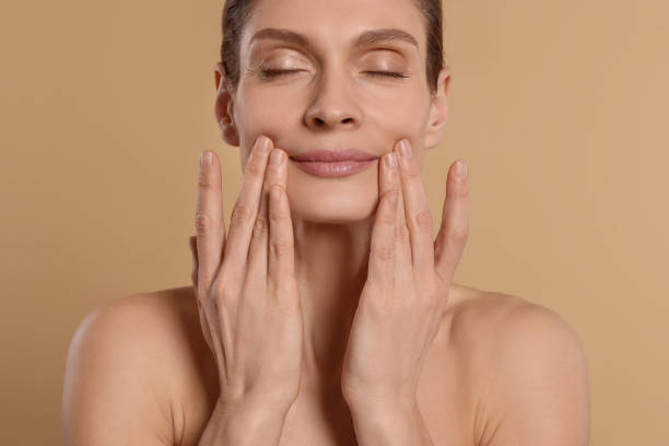 istock Woman massaging her face on beige background 1779330366