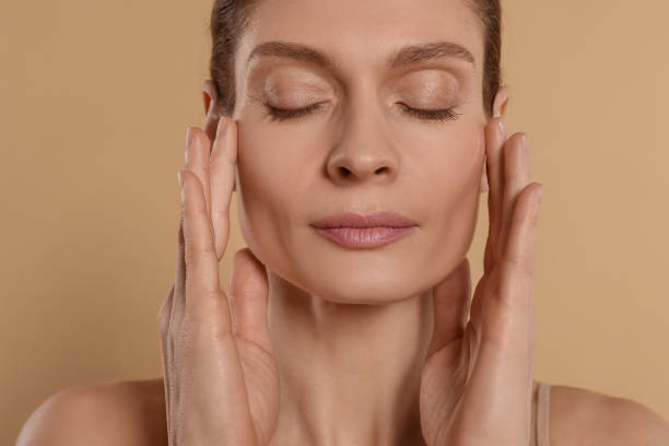 istock Woman massaging her face on beige background 1779330884
