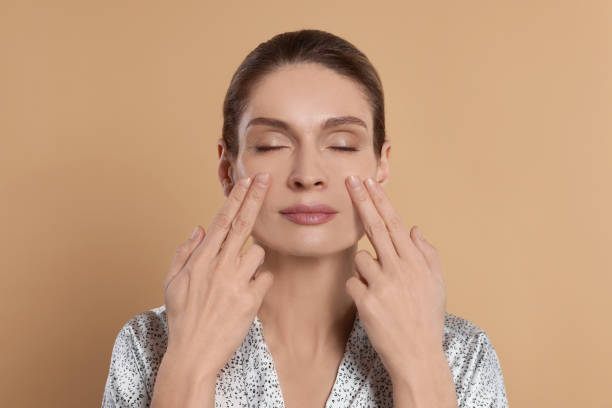 istock Woman massaging her face on beige background 1779330897