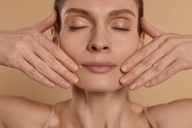 istock Woman massaging her face on beige background 1779331975