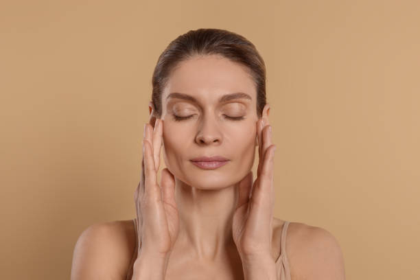 istock Woman massaging her face on beige background 1779331978