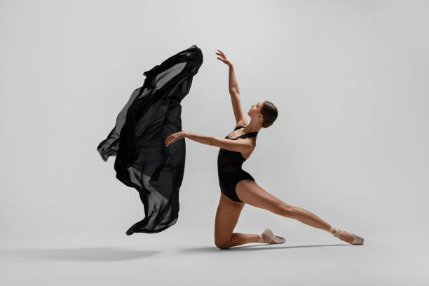 istock Graceful young ballerina practicing dance moves with black veil on white background 1779334119