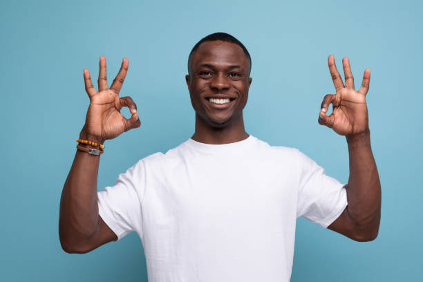 istock nice young african guy in white t-shirt smiling showing class with hands 1779351958