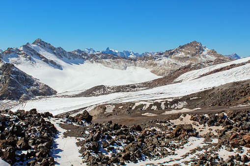 Black rocks and glaciers at the Mount Elbrus, Russia. Blue sky with copy space for text