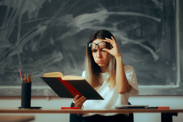 istock Confused Teacher Checking the Information from a Textbook with Factual Errors 1779443437