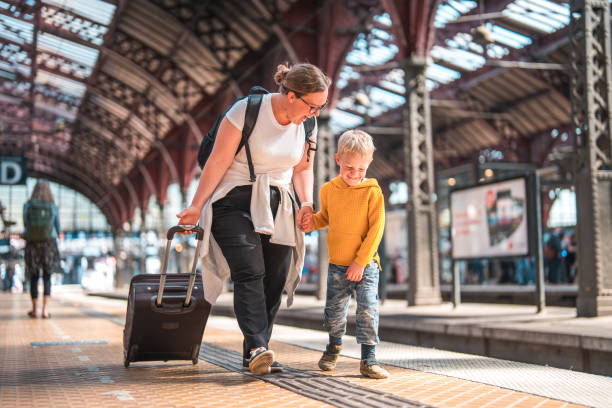 A family, comprising a Caucasian mother and her son, standing at the Copenhagen train station.
