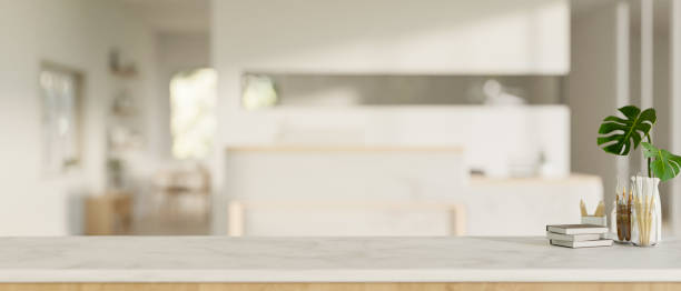 istock Copy space on a white table over a blurred background of a modern white office lobby with a counter. 1779479517