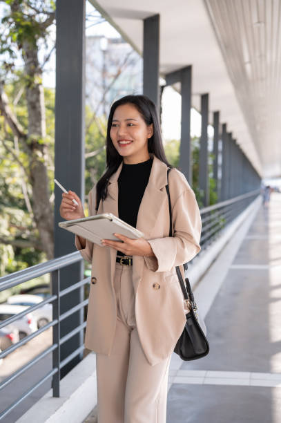 istock A beautiful Asian businesswoman is thinking about her project while walking on a skywalk. 1779488594