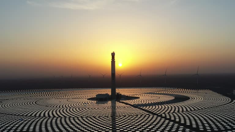 Concentrated solar thermal power plant and wind farm at twilight