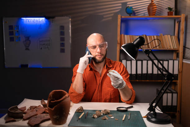 istock Archeologist calling on mobile phone and working late night in office 1779558832