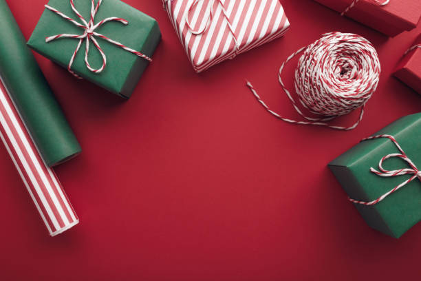 istock Christmas gift boxes with paper's rools and decorations on red background. 1779564892