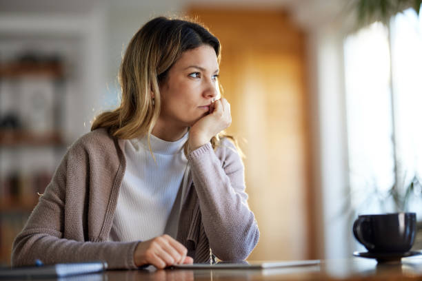 Pensive woman at home.