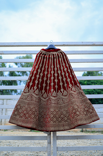 A closeup shot of bridal lehenga or ankle-length skirt for the wedding event hanging in balcony