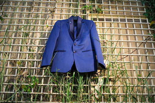 A closeup shot of a tuxedo prom wedding groom suit blazer, jacket, or coat displayed during the wedding day