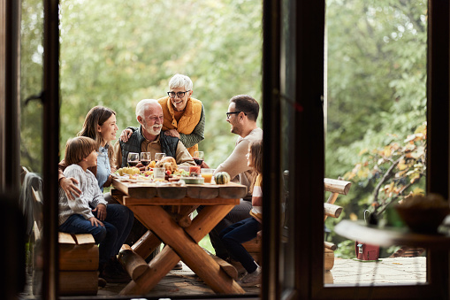 Happy extended family enjoying in lunch on a terrace. Copy space.