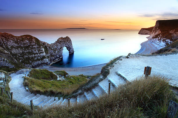 Picturesque photo of Durdle Door Sunset Durdle Door Sunset on the jurassic coast dorset england jurassic coast world heritage site stock pictures, royalty-free photos & images