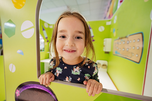 Close up portrait of girl playing at indoor play center playground.