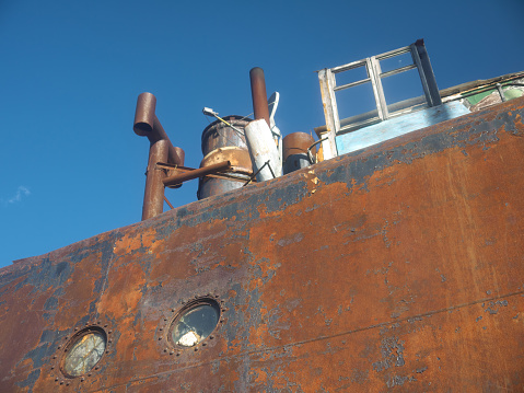 A rusty, stranded and sunken shipwreck vessel.