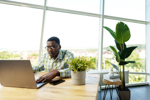 istock Serious concentrated african man studying or working with laptop indoors 1779629016